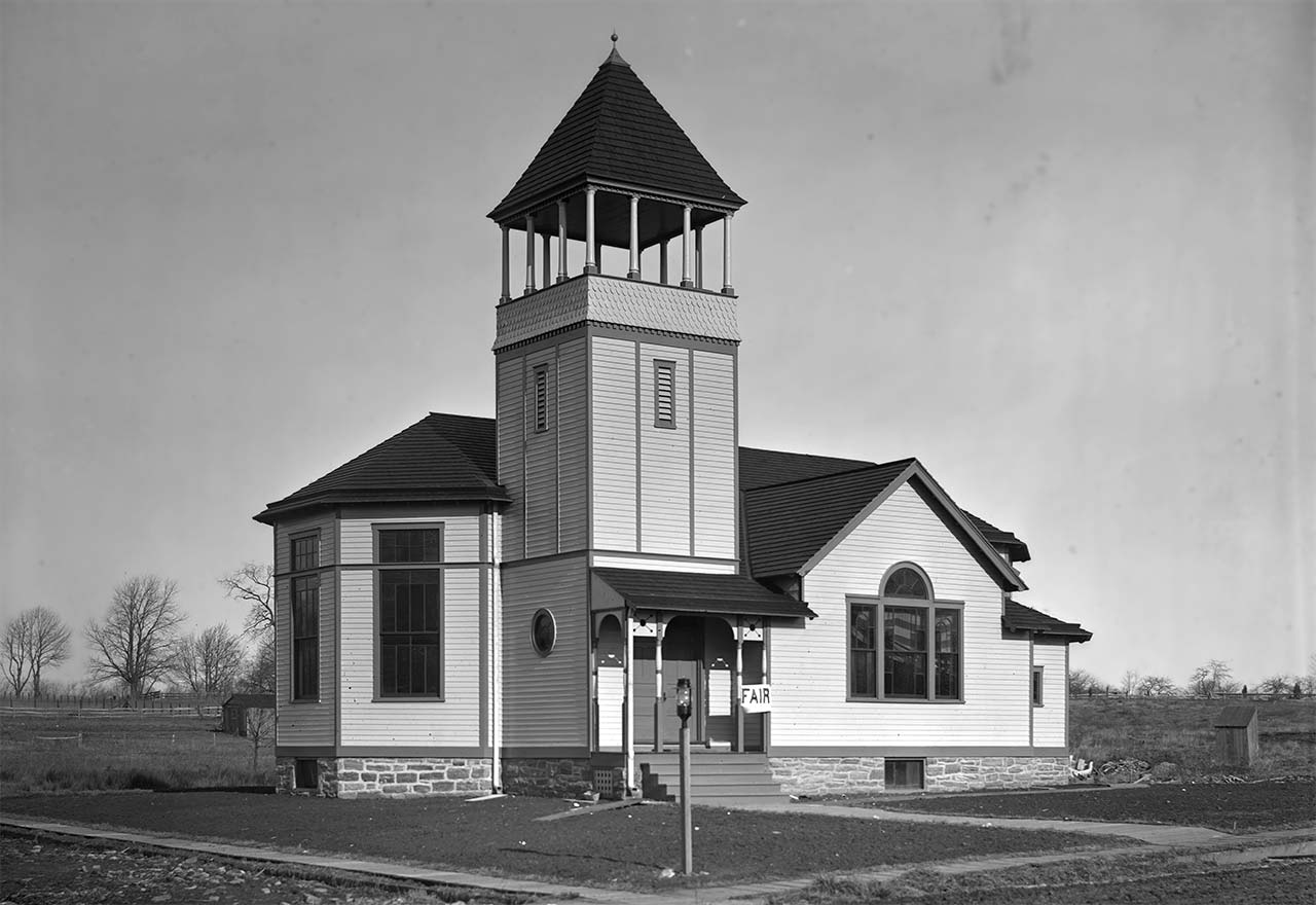 small white church surrounded by open land