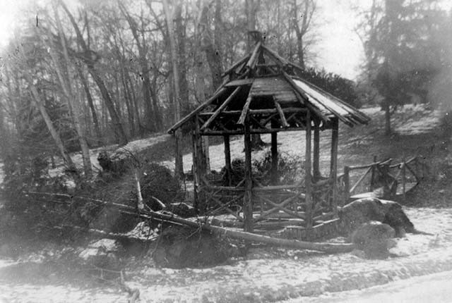 wooden gazebo in disrepair, roof falling in