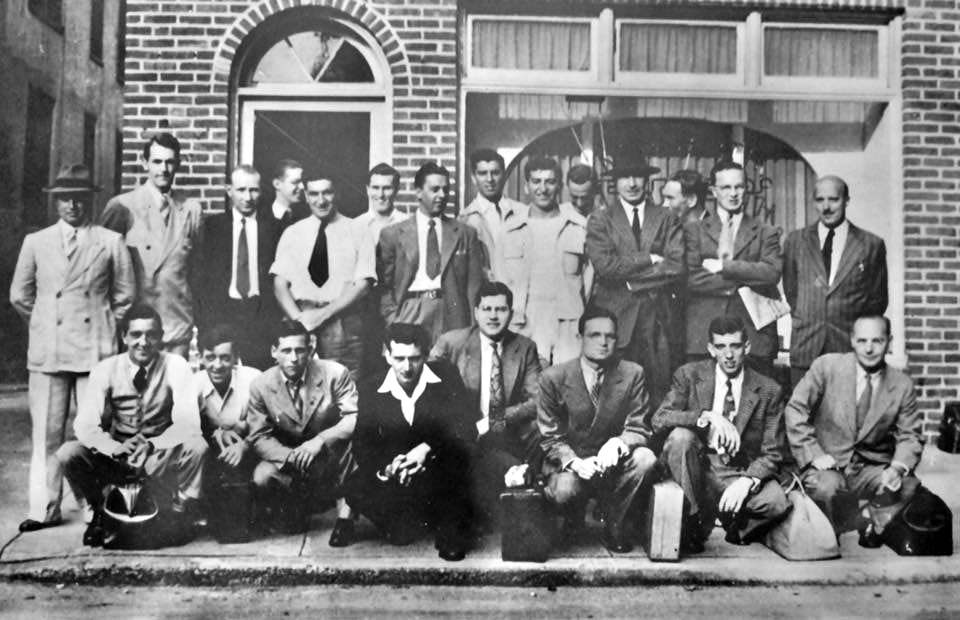 22 young men, most in jackets and ties, posing in 2 rows