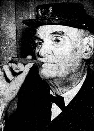 old man wearing a civil war cap puffs on cigar