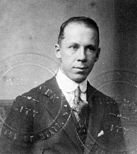 young man in tie, photo marked with passport stamps