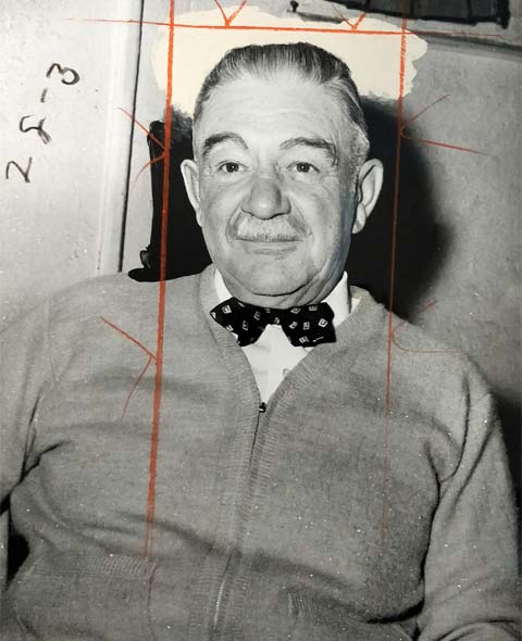 older man with mustache wearing bow tie, zippered seater