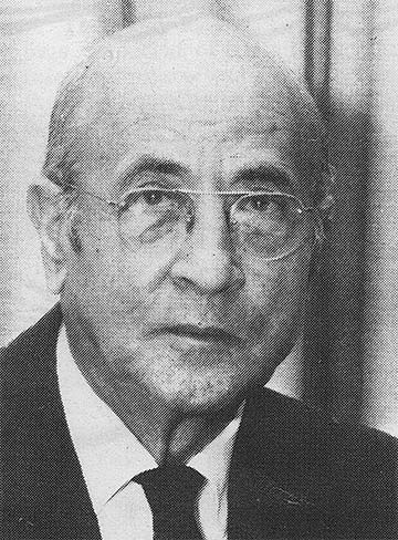 older, bald man with glasses, suite and tie