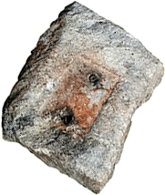 rough stone block with 2 holes bored in the middle and rust staining