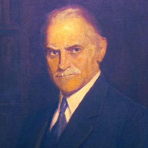 painting of a serious-looking older man with a mustache in a dark suit on a dark background